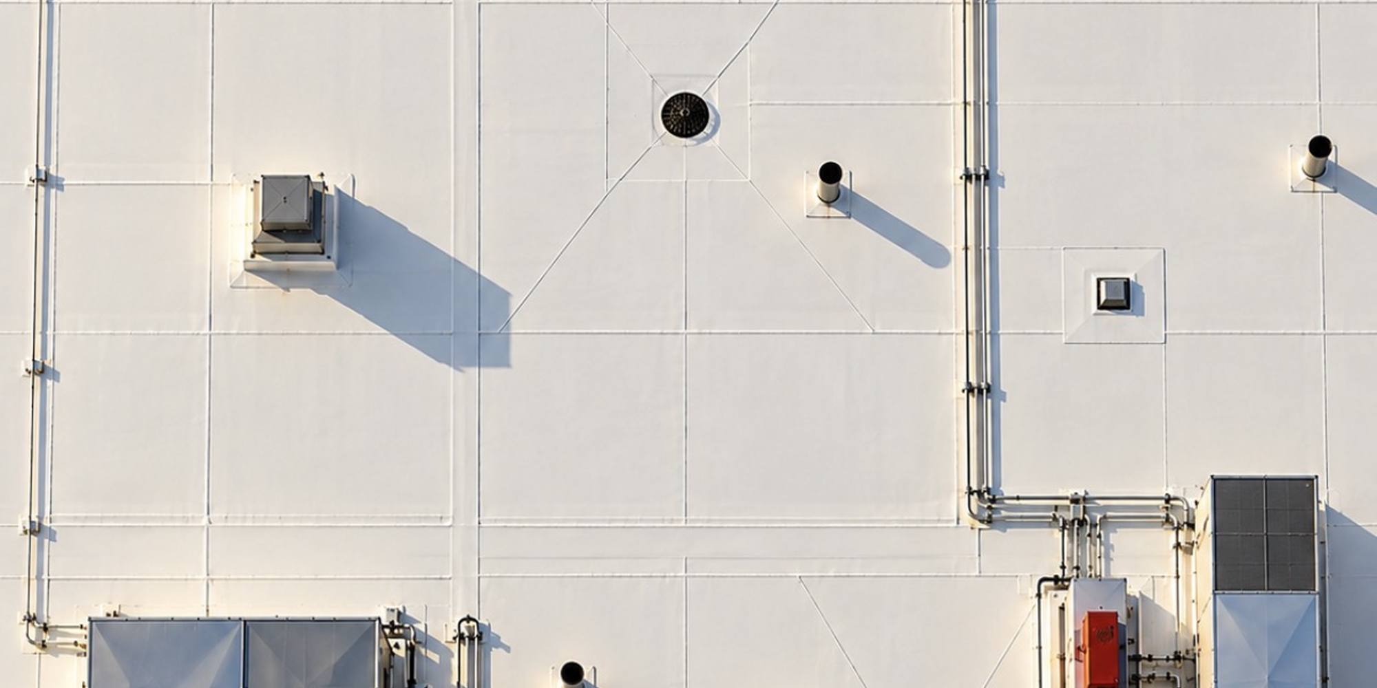 Overhead view of a clean white membrane roof with rooftop HVAC units